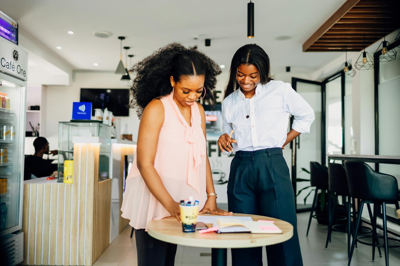Two women engaged in collaborative work at a modern café in Lagos, Nigeria.